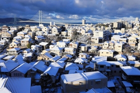 明石海峡大橋を望む住宅街。昨夜からの降雪で屋根が白く染まった＝２５日午前７時５８分、神戸市垂水区高丸５から