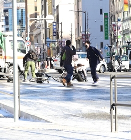 凍り付いた道路で転ぶ人々＝２５午前８時５０分、神戸市中央区