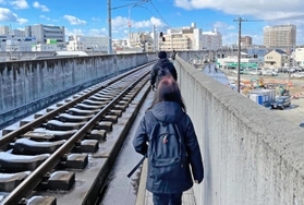 高架の線路わきを歩いて加古川駅に向かう乗客ら＝２５日午前１１時５５分、加古川市加古川町溝之口