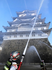 姫路城大天守に向かって放水する消防隊員ら＝２６日午前、姫路市本町