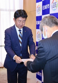 尼崎市の松本眞市長に要望書を手渡す尼崎市暴力団追放推進協議会の会長＝尼崎市役所