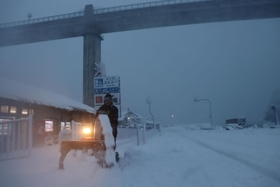 歩道に積もった雪を除雪する男性＝２８日午後、香美町香住区余部