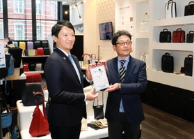 豊岡鞄ＫＩＴＴＥ丸の内店で、運営会社の西田正樹代表（右）に認証書を手渡す斎藤元彦知事＝東京都千代田区
