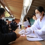 縁起物を手渡す長田神社の巫女＝１日午前、神戸市長田区長田町３、長田神社