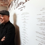 クラウドファンディングで寄せられた応援のメッセージに支えられたという片山行茂代表。ライブハウス「ソープ・オペラ・クラシックス梅田」の入り口に大きく掲示している＝大阪市北区西天満４