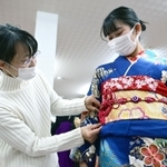 母親の吉村幸子さん（左）が愛用した振り袖を着付けてもらう娘の若菜さん＝尼崎市武庫之荘２、きもの利休尼崎本店