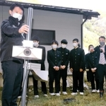 夢が丘中学校に設置されたシカよけの超音波スピーカー。斎藤元彦知事（左端）も視察に訪れた＝昨年１１月下旬、兵庫県新温泉町細田