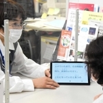 文字起こしアプリを使った実験で、窓口の市民に対応する三木市職員（左）＝昨年１２月、三木市役所