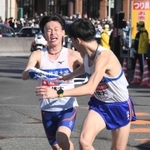 ２区、たすきを渡す日体大・藤本珠輝（左）＝戸塚中継所