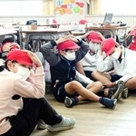 神戸市内の小学校で行われた避難訓練。余震も想定し、子どもたちは頭を手で押さえた＝２０２２年１１月（撮影・中西幸大）