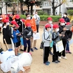 大学生と一緒に、公園の防災倉庫を見学する西灘小の５年生ら＝神戸市灘区都通３