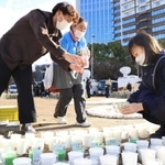 灯籠で「むすぶ」の文字を形作り、準備作業をする人たち＝１６日午後、神戸市中央区加納町６