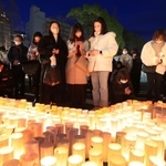 阪神・淡路大震災の犠牲者に祈りを捧げる人たち＝１６日午後５時４６分、神戸市中央区加納町６、東遊園地
