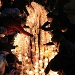 紙灯籠に火をともすボランティアら＝１６日午後、神戸市中央区加納町６、東遊園地