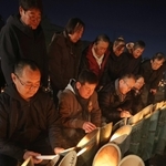 竹灯籠を前に祈りをささげる宮城県名取市の被災者ら＝１７日午前、神戸市中央区加納町６