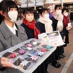 花飾りを用意し、募金への協力を呼びかける神戸常盤女子高校の生徒＝１７日午後４時３２分、神戸市長田区若松町