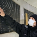 母と妹の名前が刻まれた銘板に触れる山田克敏さん＝１７日午前５時５８分、神戸市中央区加納町６、東遊園地