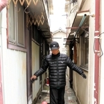 危険密集市街地で、家と家の間の狭い通路を示す駒ケ林まちづくり協議会会長の浦井清五さん＝神戸市長田区駒ケ林町１