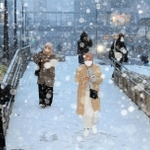 降りしきる雪の中を歩く人たち＝２４日午後４時５０分、姫路市駅前