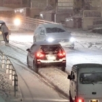 急な積雪で路面が真っ白になった上り坂。スリップする車両が相次ぎ、後ろから車を押す人もいた＝２４日午後８時３３分、神戸市垂水区星陵台