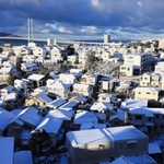 明石海峡大橋を望む住宅街。昨夜からの降雪で屋根が白く染まった＝２５日午前７時５８分、神戸市垂水区高丸５から