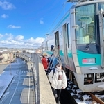 はしごを使って車両から高架の線路上に降りる乗客ら＝２５日午前１１時５３分、加古川市加古川町溝之口
