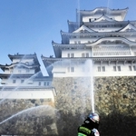 姫路城大天守に向かって放水する消防隊員ら＝２６日午前、姫路市本町