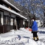 ＪＲ竹田駅前で雪かきをする女性。１月の観測史上最低となる冷え込みを記録した＝２６日午前、朝来市和田山町竹田