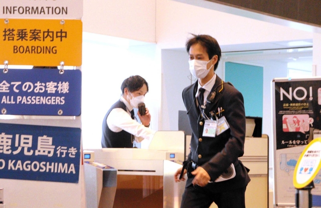 搭乗客を案内する森山篤志さん（左）とマブチ・シンイチさん。定時運航に向けて最後の搭乗客を捜す＝神戸市中央区、神戸空港