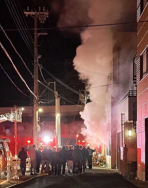 激しく白い煙を出して燃える集合住宅＝１月２２日午前１時５３分、神戸市兵庫区湊町１（近隣住民提供）