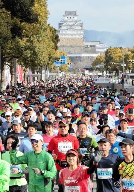 姫路城を背に一斉にスタートするランナー＝２６日午前、姫路市の大手前通り