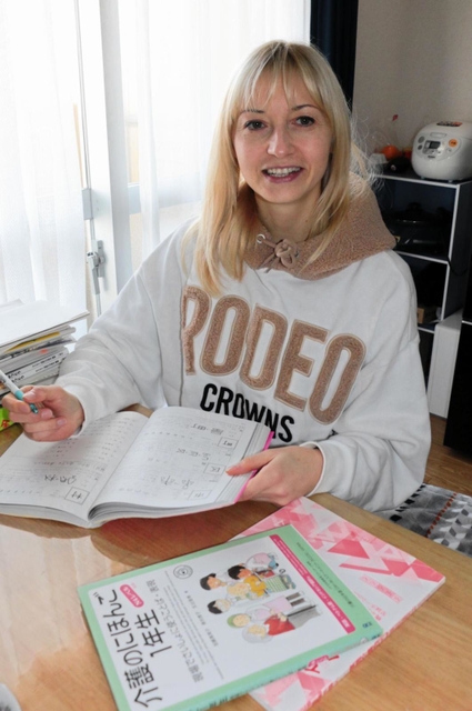 寄付された家具に囲まれ、日本語の勉強に励むハンナ・シドロバさん＝神戸市須磨区内