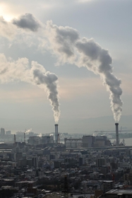 白い水蒸気を上げる神戸製鋼所の石炭火力発電所。４号機の稼働で国内最大級となった＝１日午前、神戸市灘区から