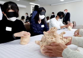 目隠しし、福来四郎氏の指導作品に触れる教師ら＝神戸市灘区鶴甲３、神戸大