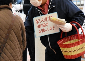 ビラを渡し、犯人逮捕に協力を呼びかける寺田さんの夫＝神戸市須磨区横尾１、市営地下鉄妙法寺駅