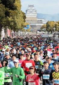 姫路城を背に一斉にスタートするランナー＝２６日午前、姫路市の大手前通り