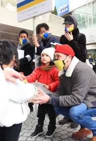 「ＫＯＢＥ三宮・ひと街創り協議会」のメンバーと共に街頭に立ち、母国への支援を呼びかけるウクライナからの避難者ら＝２３日午前、神戸市中央区三宮町１