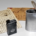 柴田順一さんが舞鶴引揚記念館に寄贈した伯父のライターやたばこ入れ、はがき＝京都府舞鶴市