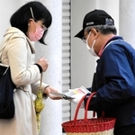 事件解決への情報提供を求め、通行人らにビラを配る寺田和子さんの夫（右）＝１９日午前、神戸市須磨区横尾１