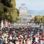 姫路城を背に一斉にスタートするランナー＝２６日午前、姫路市の大手前通り