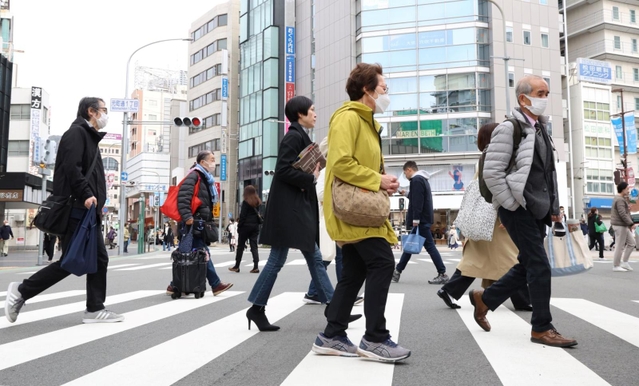 マスク着用が「個人の判断」とされ、通勤の人波にはマスクをしていない人の姿もあった＝１３日午前、神戸市中央区元町通１