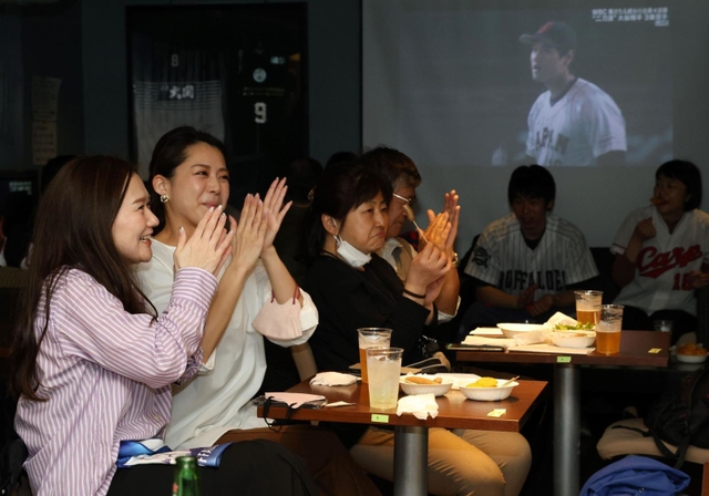 １回表、大谷翔平投手がイタリアの１番打者から三振を取り、拍手を送る野球ファンら＝１６日夜、神戸市中央区古湊通１、スポーツカフェバー「スポルテリア」