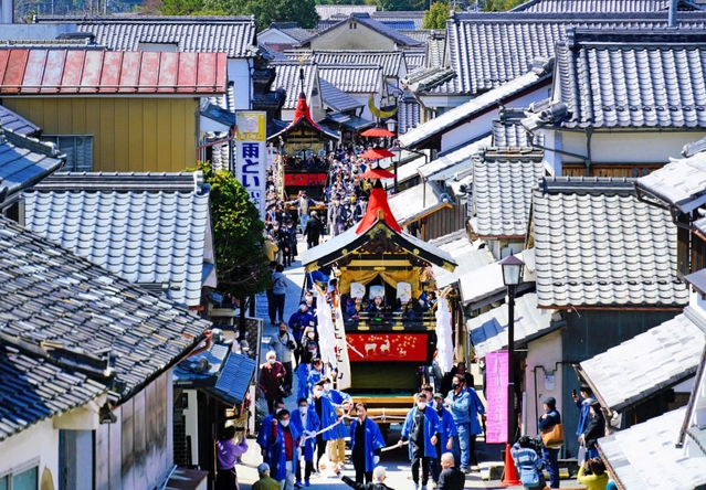 １世紀ぶりに復活を遂げた「鉾」を屋根に立て、電柱がなくなった通りを進む２基の鉾山＝１９日午前、丹波篠山市河原町