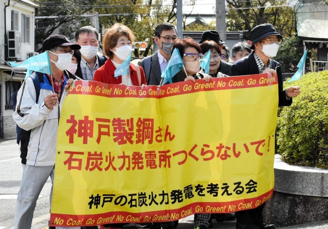 横断幕を掲げて裁判所へと向かう住民関係者ら＝神戸市中央区橘通２、神戸地裁