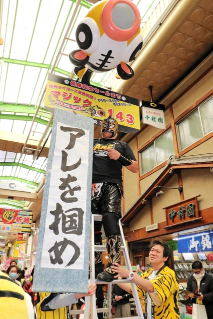 阪神タイガースの優勝を祈って、マジック「１４３」を取り付けた、尼崎中央３丁目商店街の名誉応援団長プロレスラー空牙（くうが）さん＝２９日午前、尼崎市神田中通３