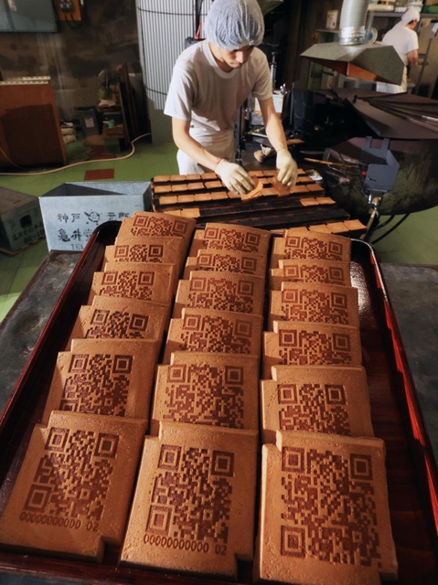 ＱＲコードが焼き付けられた瓦せんべい。伝統の味に載る現代模様の意外性が好評という＝神戸市中央区元町通６、亀井堂総本店