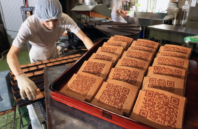 ＱＲコードが焼き付けられた瓦せんべい。伝統の味に載る現代模様の意外性が好評という＝神戸市中央区元町通６、亀井堂総本店
