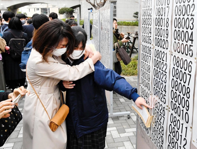 自身の番号を見つけ、喜び合う生徒ら＝１７日午前、神戸市長田区池田谷町２、長田高校