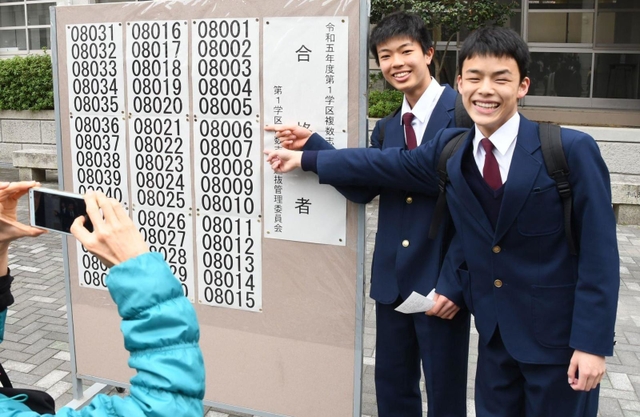 自身の番号を見つけ、喜び合う生徒ら＝１７日午前、神戸市長田区池田谷町２、長田高校