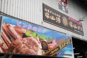 「柴山がに」の看板。「厳選の証し！！」「選別日本一！！」の文字が躍る＝柴山港